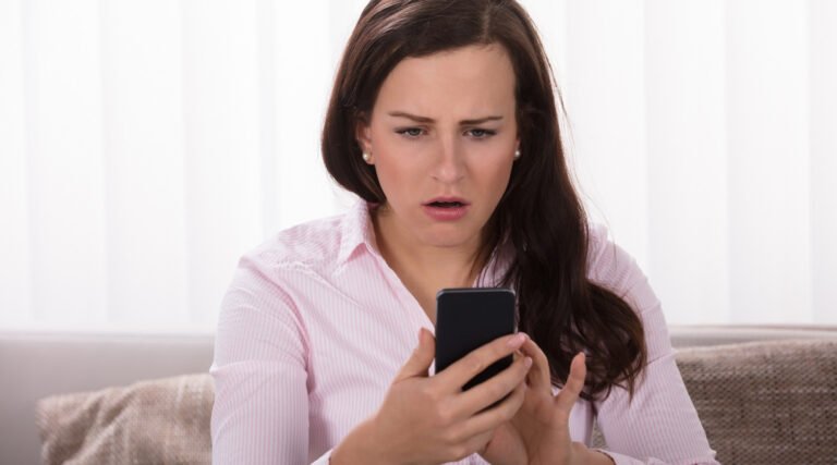 shocked-woman-looking-at-mobile-phone-mp24738148