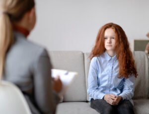 Psychological Help. Worried sad teen girl talking to psychologist