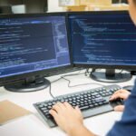 Male,Programmer,Working,On,Desktop,Computer,At,White,Desk,In